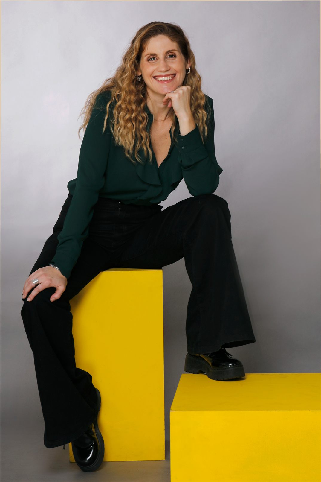 Mentora de Pramana sonriendo, sentada con camisa verde