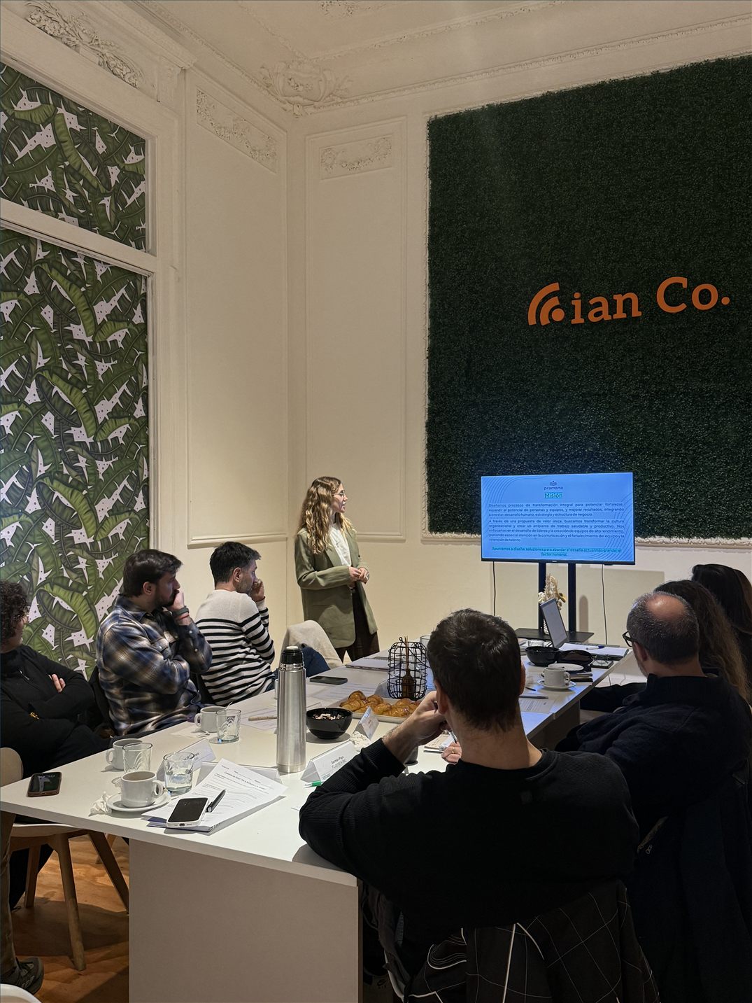 Equipo reunido alrededor de una mesa durante un encuentro de Pramana